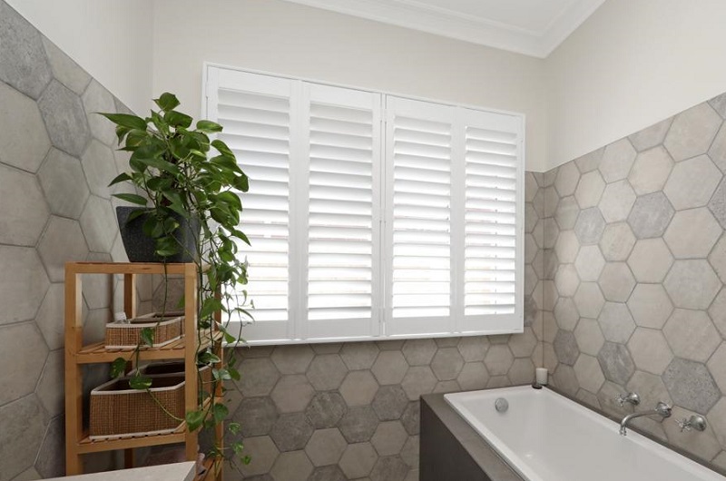 White PVC Plantation Shutters with 4 panels opened in a bathroom setting in Windsor 3181 VIC
